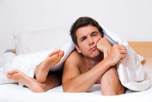 man thinking in bed